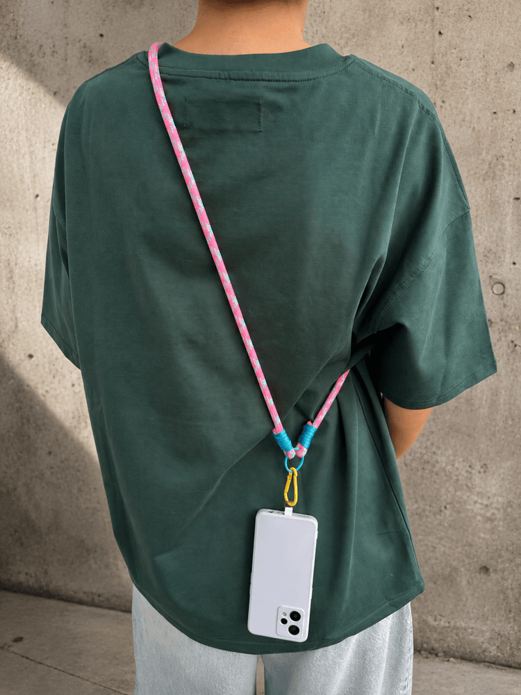 Różowo-turkusowy phone strap crossbody noszony z telefonem z tyłu