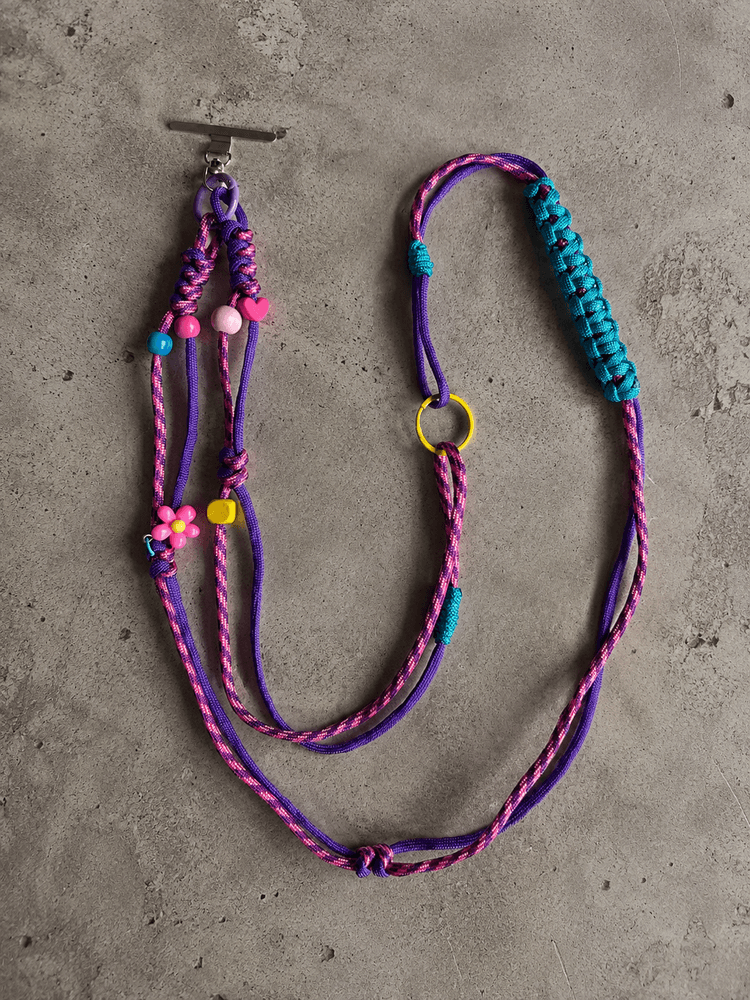 Fioletowo-różowy phone strap crossbody z turkusowym splotem i kwiatowymi detalami