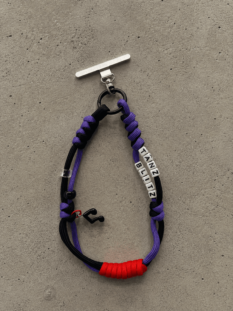 Czarno-fioletowy phone strap z napisem Tanz Blitz